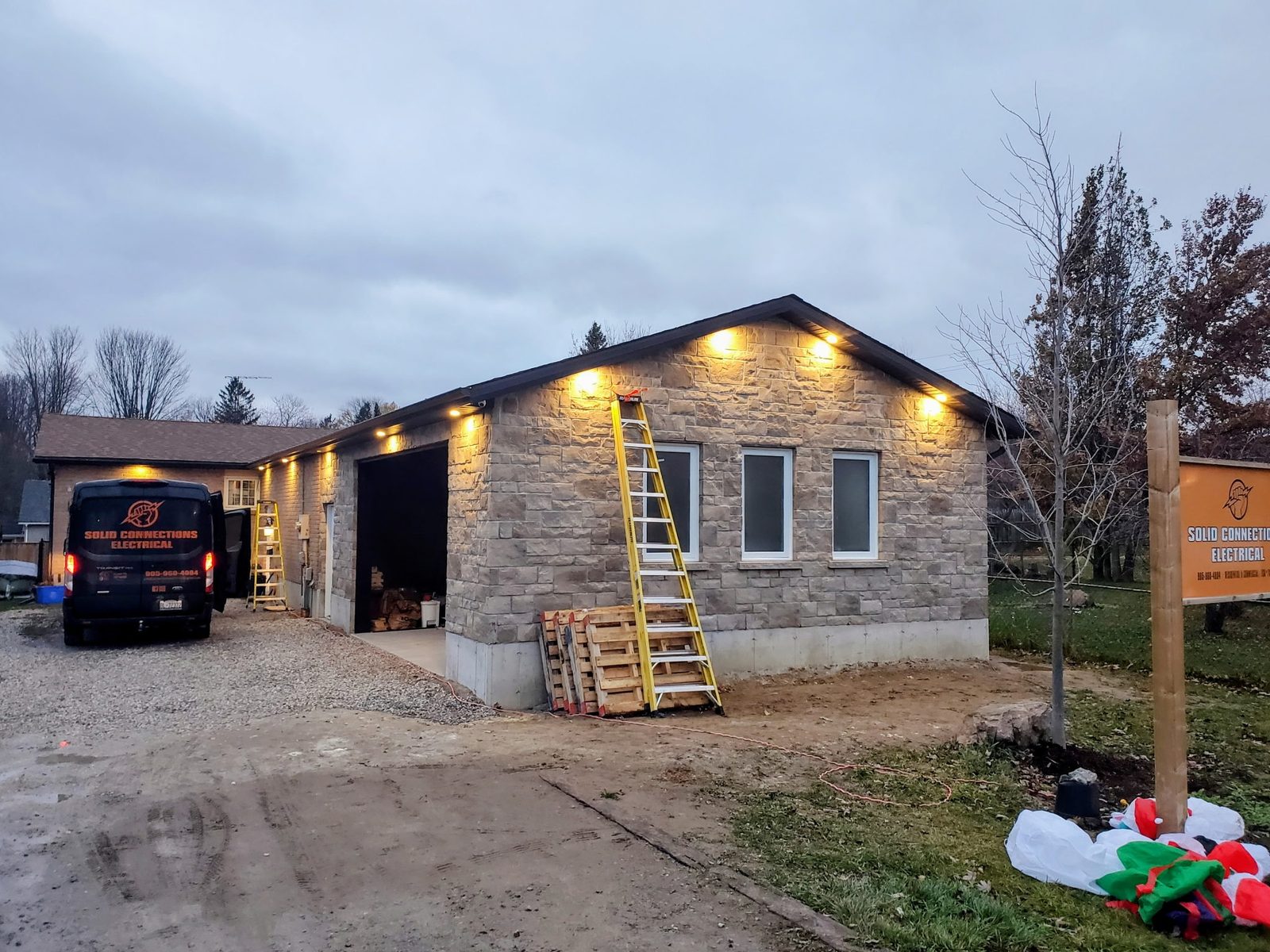 Stone building exterior with newly installed soffit lighting at dusk
